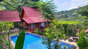 a house with a red roof and a swimming pool at Aramaya Hills Boutique in Banjar