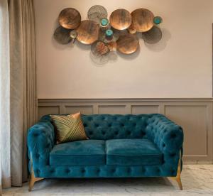 a blue couch in a living room with shells on the wall at Hill View Vythiri Holiday Home in Vythiri +9 photos