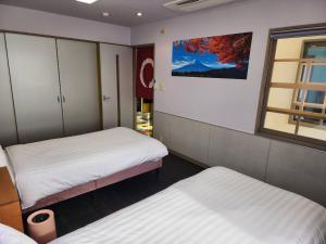 a small room with two beds and a window at Takayama Fortune-inn in Takayama
