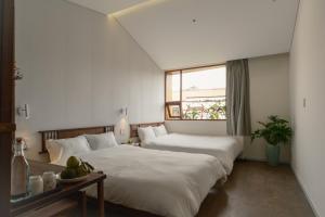 a hotel room with two beds and a window at Amea Homestay in Thôn Kim Long (1)