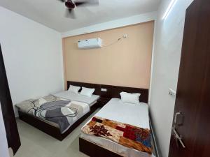 two beds in a small room with a fan at Hotel Dayalu palace in Vrindāvan +15 photos