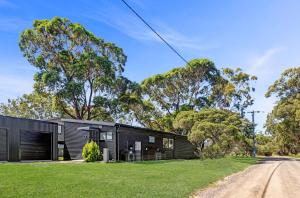 a black house with trees in the background at Sheoak in Paynesville