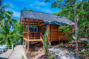 a small wooden house with a black roof at BaraCoco Bungalows in Bira