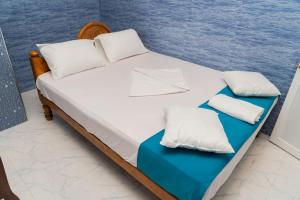 a bed with two pillows and an envelope on it at Risha villa in Trincomalee +24 photos
