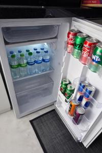 an open refrigerator filled with bottles of water and sodas at Studio Central - Climatizado - Prático in Erval dʼOeste