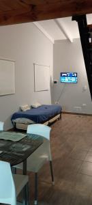 a room with a bed and a table and a tv at Relax apart in Trelew