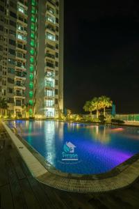 a large swimming pool in a city at night at AC Nera Garden Apartment in Thôn Văn Dương