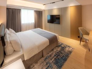 a hotel room with a bed and a television at Inn Hotel Macau in Macau