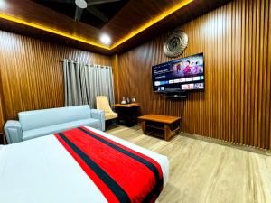 a bedroom with a bed and a flat screen tv at HOTEL N K RESIDENCY in Guwahati