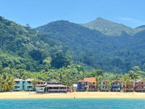 a group of houses on a beach next to the water at Beach Shack Loft Side Seaview in Tioman Island