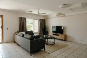 a living room with a couch and a tv at Unit 2, Rocky CBD in Rockhampton