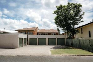 a house with two garage doors and a fence at Unit 2, Rocky CBD in Rockhampton +9 photos