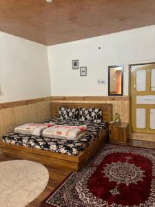 a bedroom with a bed and a rug at Dungkhar homestay in Kaza