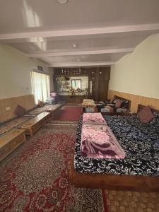 a large room with several beds and a rug at Dungkhar homestay in Kaza