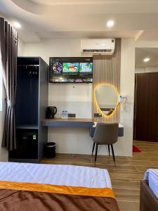 a bedroom with a bed and a mirror and a chair at Phương Ngân HOTEL in Hà Tiên