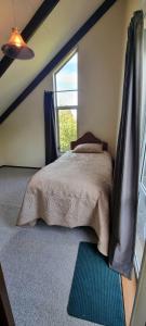 a bedroom with a bed with a window and a rug at Waypoint Lodge in Naseby
