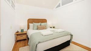 a bedroom with a large bed with two towels on it at Sea Light in Currarong