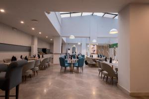 a dining room with tables and chairs and a ceiling at Hotel One Gujranwala in Kot Mergulla