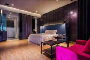 a bedroom with a bed and a table and a couch at AmanCity Motel in Pingtung City