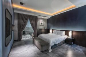 a bedroom with a bed and a tv in it at AmanCity Motel in Pingtung City +25 photos