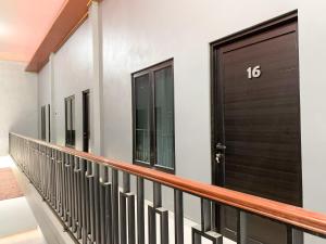 a balcony with a black door on a building at Urbanview Hotel The Corner Pandowo in Ngaglik