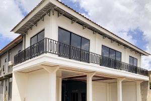 a white house with a balcony on top of it at Urbanview Hotel The Corner Pandowo in Ngaglik