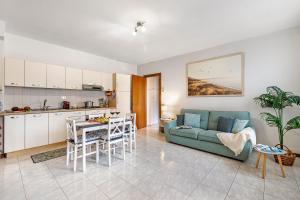 a kitchen and a living room with a couch and a table at Petalo Bianco: 100m from Lake, Parking and Balcony - Happy Rentals in Baveno