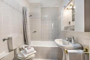 a bathroom with a toilet and a sink and a bath tub at Petalo Bianco: 100m from Lake, Parking and Balcony - Happy Rentals in Baveno