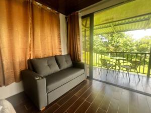a couch sitting on a balcony with a table at INTUS Lodge Rio Celeste in El pilon