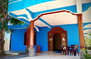 a blue house with chairs and tables in front of it at Nilaveli Better Beach Resort in Nilaveli
