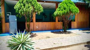 two trees in front of a house with a fence at Nilaveli Better Beach Resort in Nilaveli