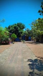 a dirt road with trees and a building at Nilaveli Better Beach Resort in Nilaveli