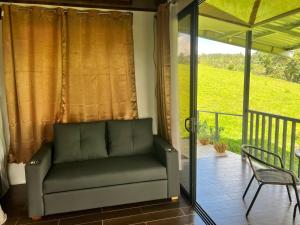 a couch sitting on the porch of a house at INTUS Lodge Rio Celeste in El pilon