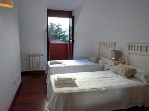 two beds in a room with a window at Hidden Gem in Ramales de la Victoria in Ramales de la Victoria