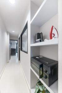 a room with a hallway with white walls and white floors at Petchaburi31 Platinum Suite Home in Bangkok