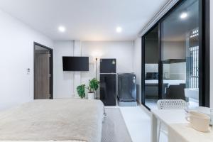 a white room with a bed and a kitchen at Petchaburi31 Platinum Suite Home in Bangkok