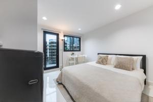 a bedroom with a large bed and a window at Petchaburi31 Platinum Suite Home in Bangkok