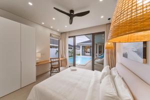a bedroom with a white bed and a ceiling fan at Valentine Village in Choeng Mon Beach +223 photos