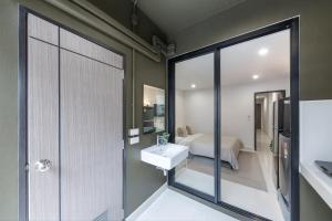 a bathroom with a sink and a bedroom at Petchaburi31 Platinum Suite Home in Bangkok +10 photos