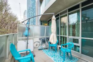 a balcony with two blue chairs and an umbrella at The Yonge Suites in Toronto