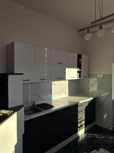 eine Küche mit weißen Schränken und einer Spüle darin in der Unterkunft Riaho Apartment in Mostar