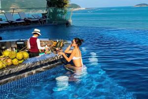 a woman sitting in the water in a swimming pool at Boton Blue Hotel & Spa in Nha Trang +73 photos
