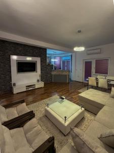 ein Wohnzimmer mit Sofas und einem großen Fernseher in der Unterkunft Riaho Apartment in Mostar