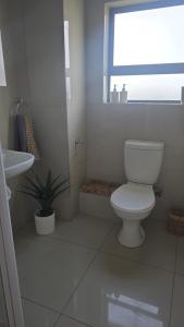 a white bathroom with a toilet and a sink at 118 on the Bay in Gordonʼs Bay +24 photos