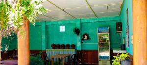 a green room with a table and a refrigerator at Nilaveli Better Beach Resort in Nilaveli +1 photo