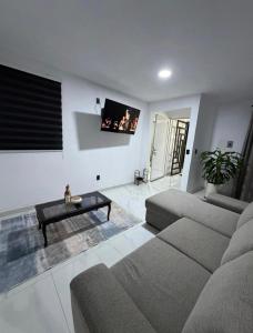 a living room with a couch and a coffee table at Casa Azteca de Oro in San Sebastian Xolalpa