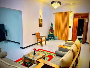 a living room with a christmas tree in the background at Akarsha Residence - Near Airport in Negombo