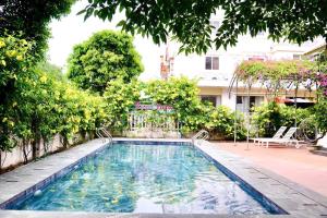 a swimming pool in a yard with trees at Tigon Villa in Mỹ Ðuc