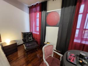 a living room with a chair and a table at Le Cœur Urban Suite Parma in Parma