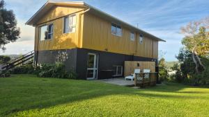 a yellow house with a lawn in front of it at Turanga Heights in Gisborne